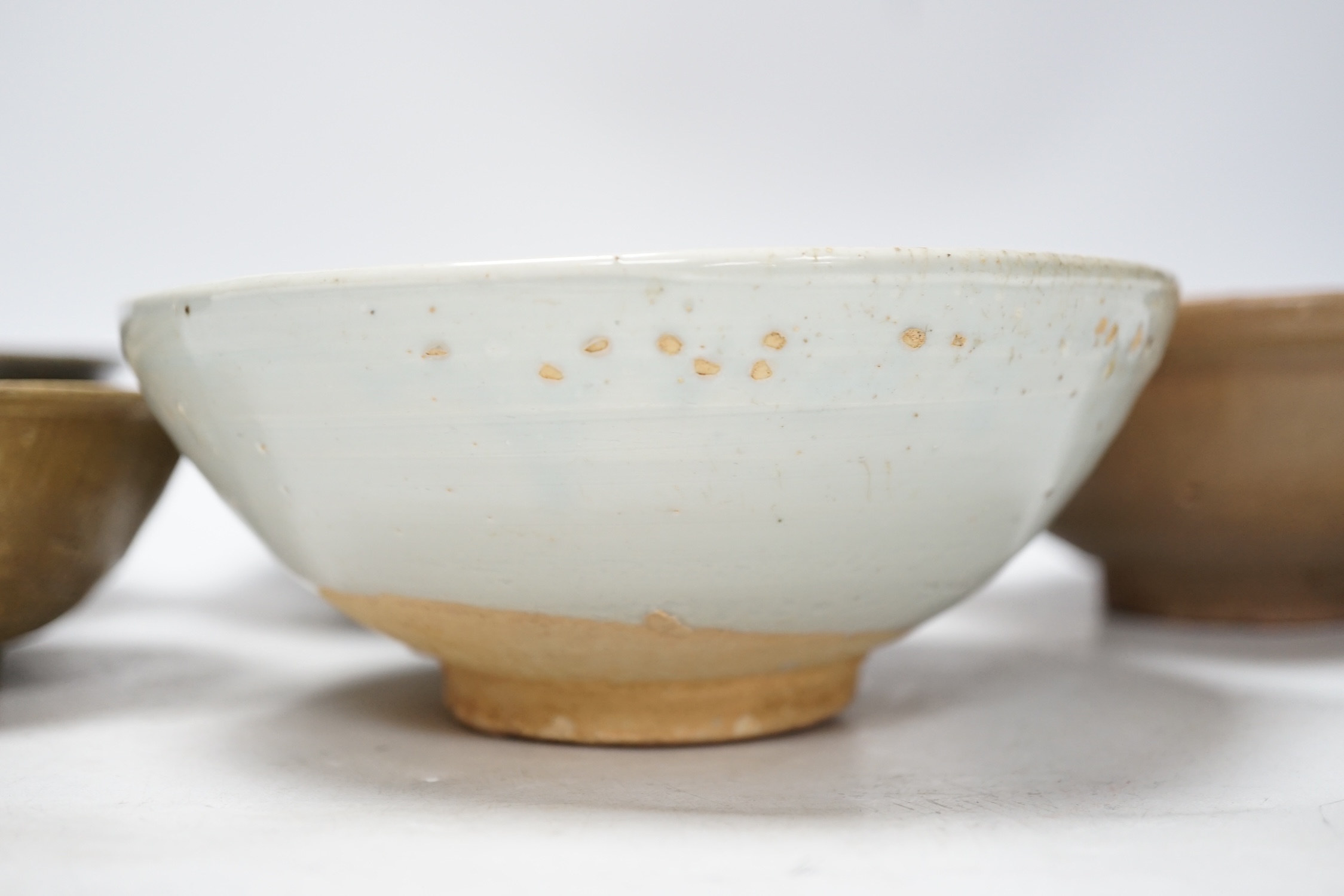 A group of four Chinese Longquan or Yue ware celadon bowls and a Qingbai bowl, Song-Yuan dynasty, largest 20cm diameter (5)